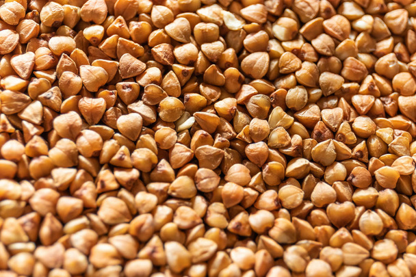 Groat buckwheat raw macro. Diet food concept. Background with focus shallow depth of field. - Fotó, kép