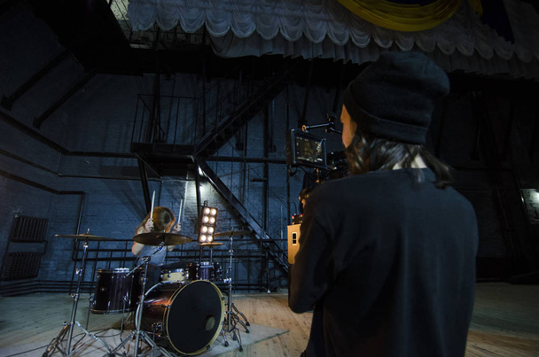 Professional videographer using cinema digital video camera for filming a drummer for a music video. - Foto, immagini