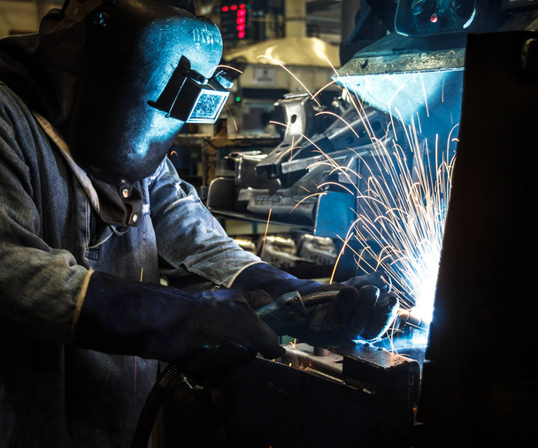 L'ouvrier industriel de l'acier accélère le mouvement dans l'usine avec masque de protection soudure métallique
 - Photo, image