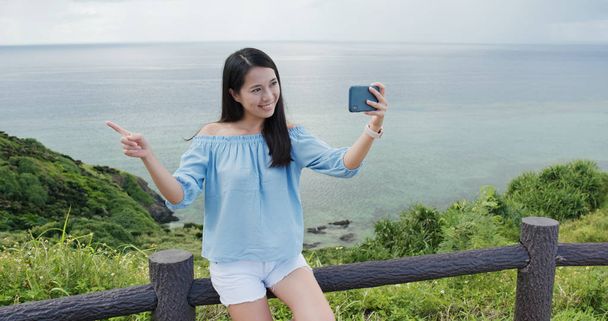 Woman take selfie on cellphone in ishigaki island landmark - Photo, image