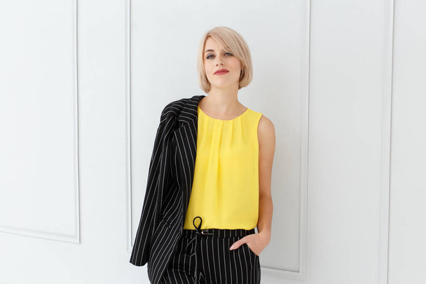 Fashion portrait of woman in yellow and black suit on light background - Fotografie, Obrázek