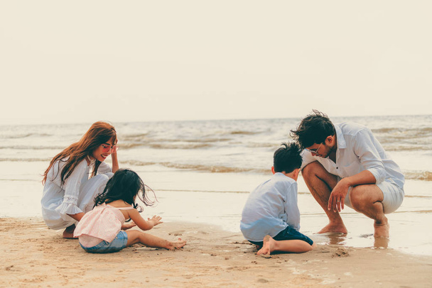 Šťastná rodina otec, matka a děti chodí dovolenou na tropické pláži s pískem v létě. - Fotografie, Obrázek