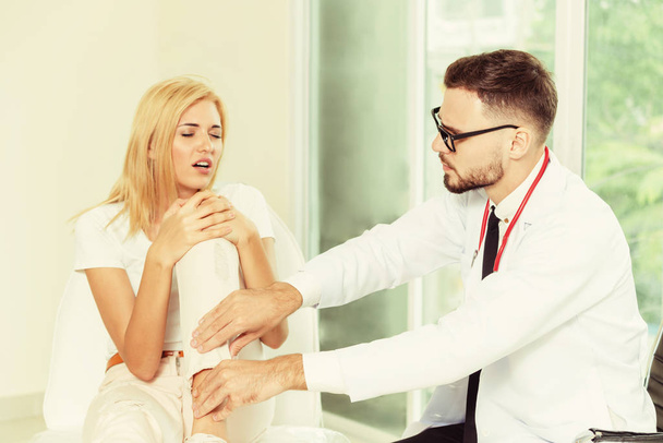 Αρσενικό ο γιατρός εξετάζει Θηλυκός ασθενής σε νοσοκομείο ward. Υγειονομικής περίθαλψης και ιατρικής υπηρεσίας. - Φωτογραφία, εικόνα