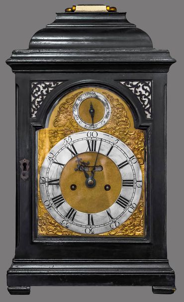 Antique table clock housed in carved wooden box on isolated gray background with clipping path. - Photo, Image