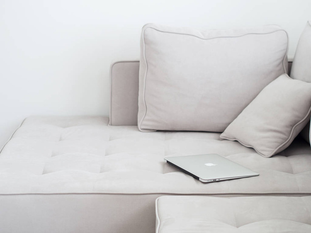Silver laptop lying on gray sofa, Minimalistic style  - Фото, зображення