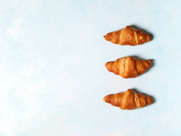 Top view of fresh french croissants on pastel blue background - Foto, Imagem