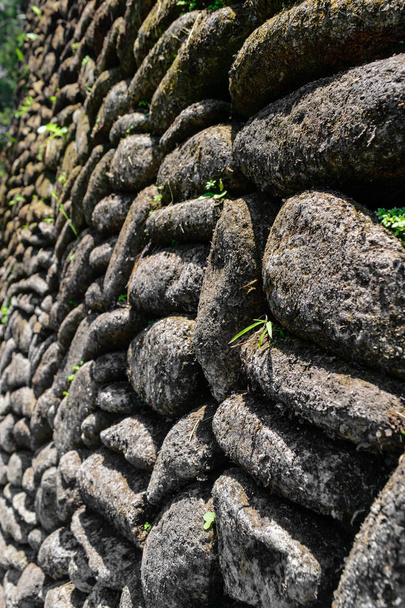 Hintergrundfläche aus perfekt platzierten Steinen Wand mit Moos und Flechten bedeckt - Foto, Bild