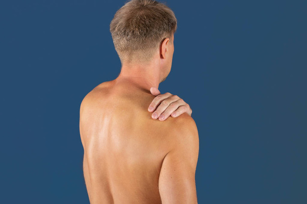Hombre sosteniendo su hombro dolorido tratando de aliviar el dolor
 - Foto, imagen