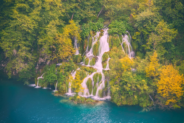 Autumn at the Plitvice Lakes National park, waterfall in the colorful forest, Croatia. Nature background suitable for wallpaper, cover or guide book - Photo, Image