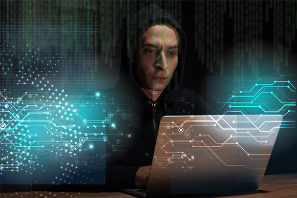 portrait of hacker in black hoodie using laptop, cuber security concept - Photo, Image