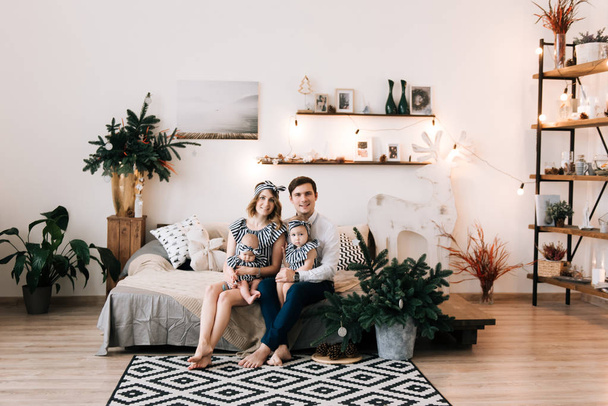 Happy parents with baby in decorated room for Christmas - Foto, Imagen