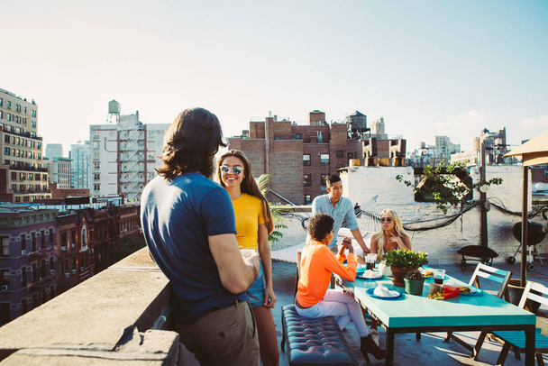 Group of friends apending time together on a rooftop in New york city, lifestyle concept with happy people - Fotografie, Obrázek