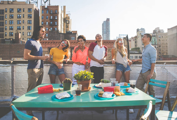 Group of friends apending time together on a rooftop in New york city, lifestyle concept with happy people - Фото, изображение