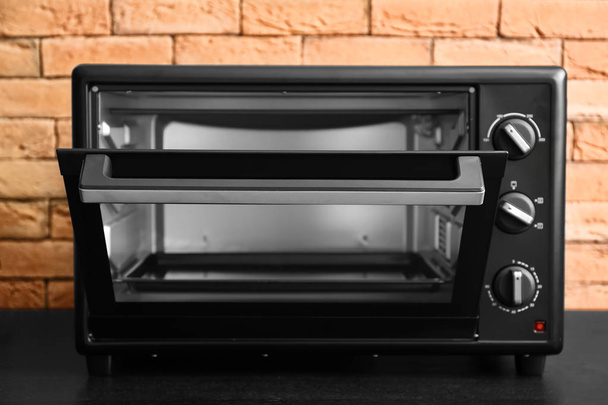 Modern electric oven on dark table - Photo, Image