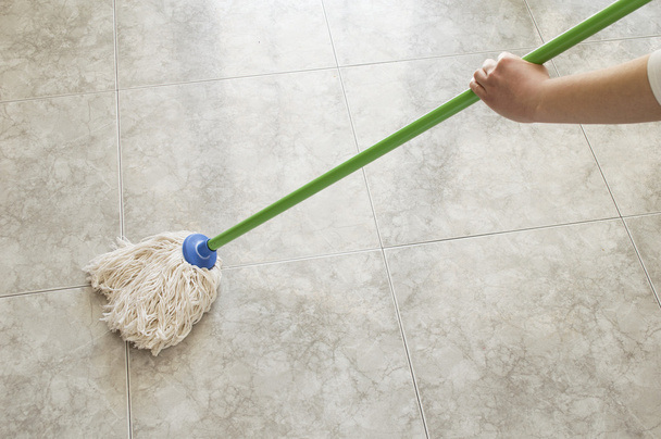 young woman scrubbing floor with a mop - Foto, Imagem