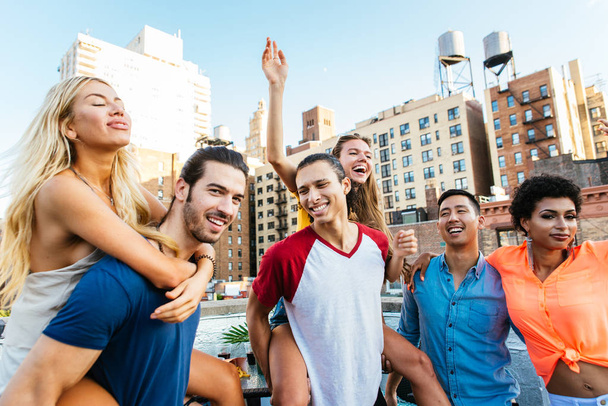 Group of friends spending time together on a rooftop in New york city, lifestyle concept with happy people - Foto, Imagem