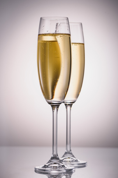 close up view of glasses of champagne on grey backdrop - Foto, Imagem