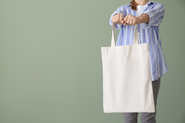 Woman with eco bag on color background - Foto, afbeelding