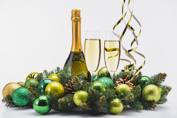 close up view of bottle and glasses of champagne with christmas wreath on white background - Photo, Image