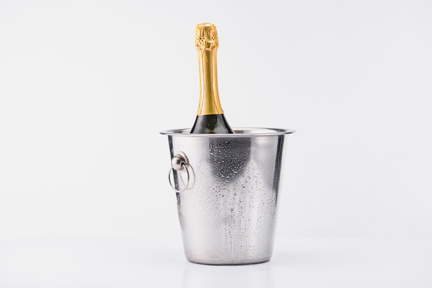 close up view of bottle of champagne in bucket on grey backdrop - Foto, Imagen