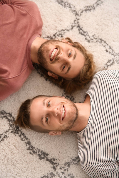 Young LGBT couple lying on floor - Zdjęcie, obraz