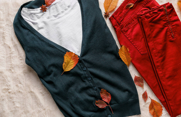 Модная теплая одежда с осенними листьями на пушистой ткани
 - Фото, изображение