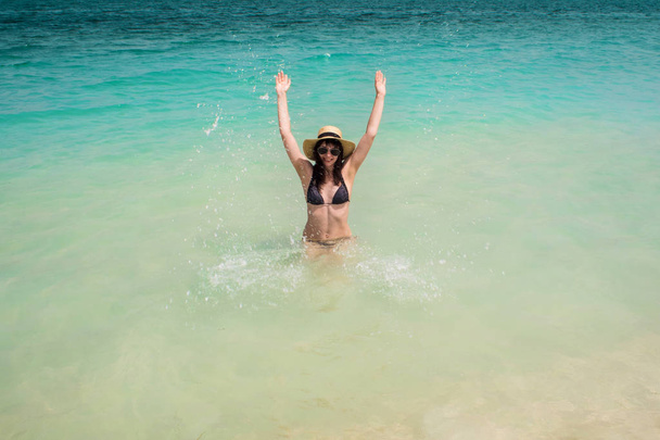 Happy young woman swimming in the azure sea. Funny girl in straw hat - Фото, зображення