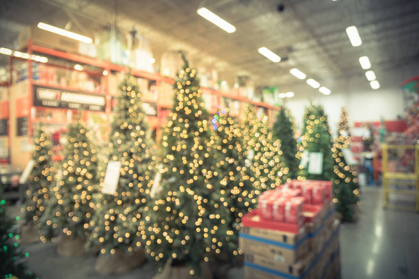 Vintage Toon wazig brede selectie van kunstmatige kerstboom decoratie bij ijzerhandel. Kransen en strijkers van bokeh lichte surround. Xmas decoratie voor verkoop in Amerika - Foto, afbeelding