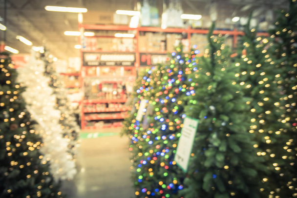 ビンテージ トーンは、人工的なクリスマス ツリーの装飾の金物店での幅広い選択をぼやけています。花輪とピンぼけ光サラウンドの文字列。アメリカでの販売のためのクリスマス装飾 - 写真・画像