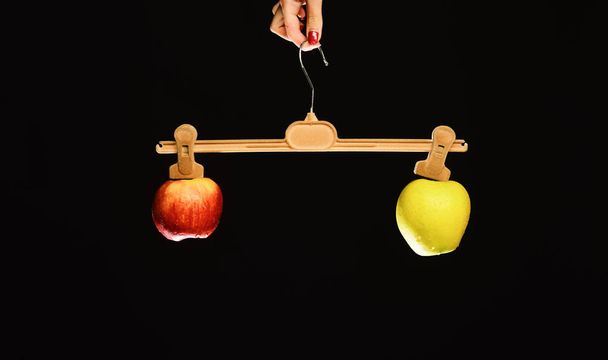 Female hand holds hanger with fruits on tips - Foto, Imagen