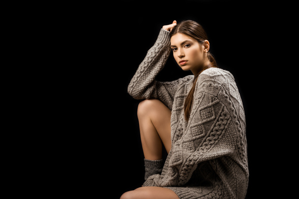 hermosa mujer en suéter gris de lana mirando a la cámara aislada en negro
 - Foto, Imagen