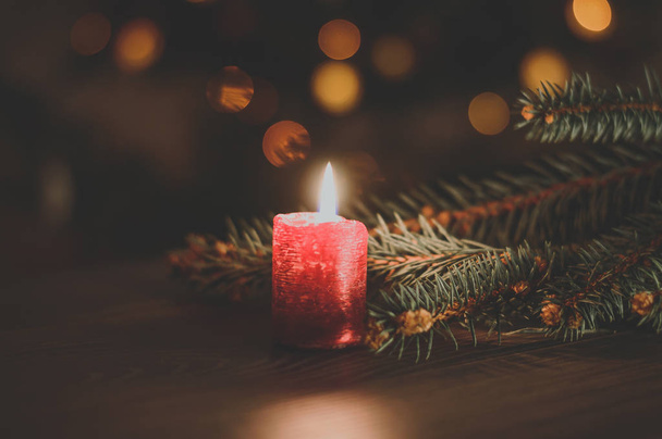 Red burning candle on Christmas tree background - Fotoğraf, Görsel