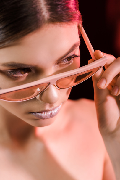 portrait of stylish model in eyeglasses posing on dark background - Fotoğraf, Görsel