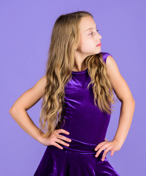 Girl child wear velvet violet dress. Clothes for ballroom dance. Kid fashionable dress looks adorable. Ballroom dancewear fashion concept. Kid dancer satisfied with concert outfit. Ballroom fashion - Фото, зображення