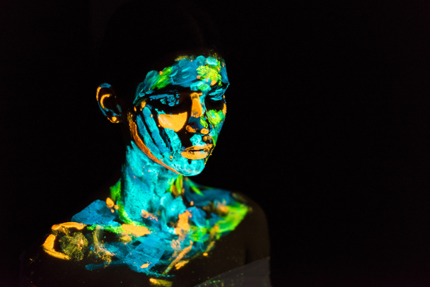 modell színes fényreklámok festékek test pózol a fekete háttér előtt - Fotó, kép