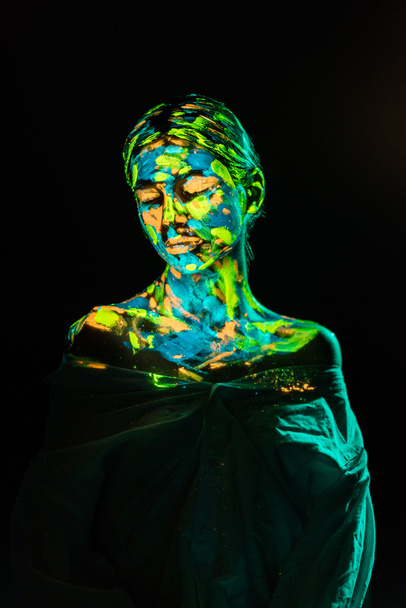model with colorful neon paints on body posing on black backdrop - Photo, Image