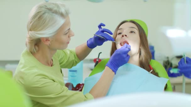 Zahnarzt, der die Zähne der Patienten mit Zahnwerkzeugen untersucht. Arzt und Patient - Filmmaterial, Video
