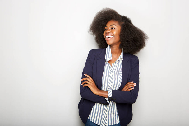 Horizontale portret van de jonge zwarte zakenvrouw lachen tegen grijze muur - Foto, afbeelding