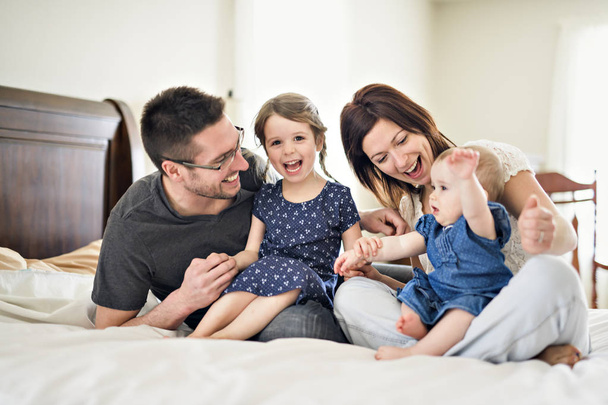 happy family mother, father and two children at home in bed - Fotoğraf, Görsel