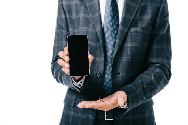cropped shot of businessman in suit showing smartphone with blank screen isolated on white - Photo, Image