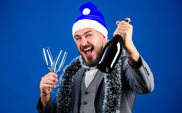 Corporate party ideas employees will love. Corporate christmas party. Man bearded cheerful hipster santa hold champagne and glasses. Christmas party organisers. Boss tinsel ready celebrate new year - Foto, afbeelding