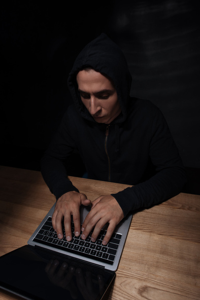 concentrated hacker using laptop at wooden tabletop, cuber security concept - Foto, Imagem
