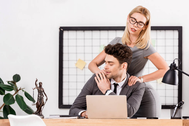 donna d'affari che fa massaggi al collega sul posto di lavoro in ufficio, concetto di romanticismo in ufficio
 - Foto, immagini