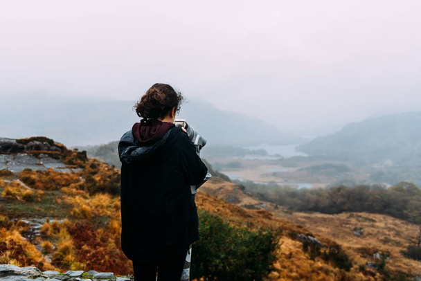 Молода жінка робить знімок в туманний краєвид в Ірландії - Фото, зображення