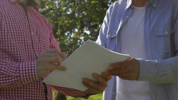 Dois agricultores irreconhecíveis concluem um acordo no pomar de maçãs
 - Filmagem, Vídeo