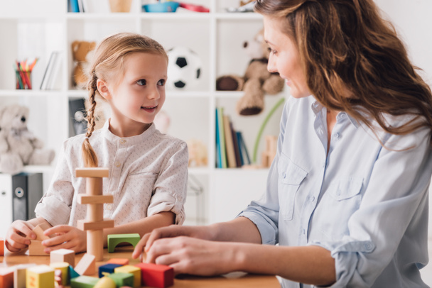 mother playing wooden blocks with adorable little daughter - Photo, Image