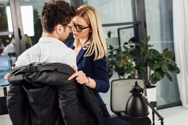 young businesswoman undressing colleague in office, flirting and office romance concept - Foto, Bild