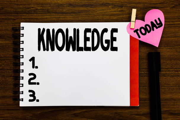 Conceptual hand writing showing Knowledge. Business photo text Facts information skills acquired through experience or education Open notebook page markers holding paper heart wooden background. - Photo, Image
