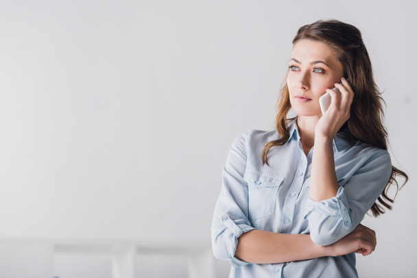 serious adult woman talking by phone and looking away - Photo, image