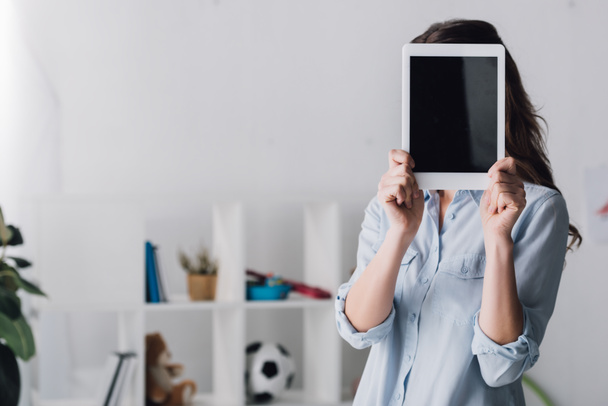 retrato de cerca de la mujer en camisa que cubre la cara con la tableta
 - Foto, Imagen